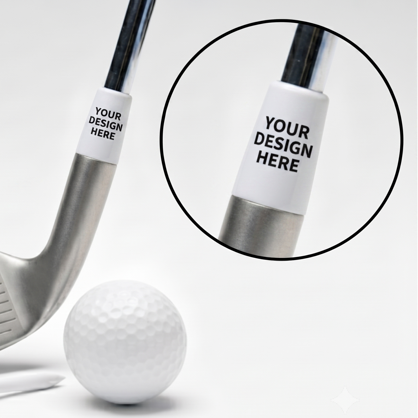 A silver golf club head with a white grip label reading 'YOUR DESIGN HERE' beside a white golf ball and tees, on a clean white background. A circular inset shows a close-up of the customizable ferrule area.